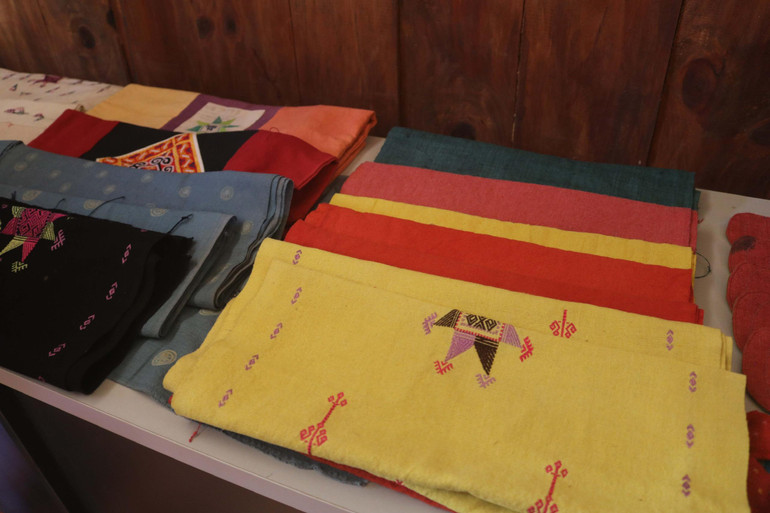 Các sản phẩm khăn quàng cổ, khăn trải bàn mang hoa văn, họa tiết độc đáo của Xưởng thêu thổ cẩm người Dao.