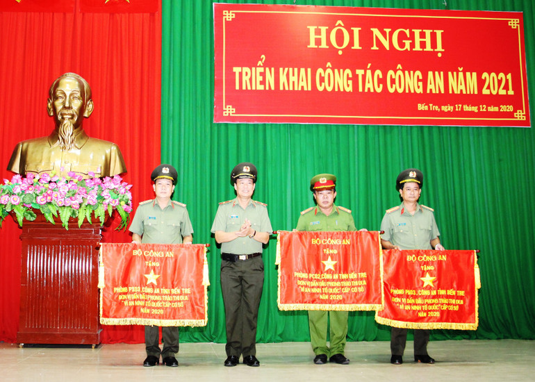 Đồng chí Trương Tấn Tùng (bìa phải) nhận cờ của Bộ Công an tặng đơn vị dẫn đầu phong trào thi đua “Vì an ninh Tổ quốc” cấp cơ sở năm 2020.