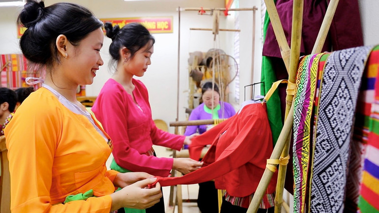 Các em học sinh tìm hiểu về trang phục thổ cẩm của người Mường ở Hòa Bình.
