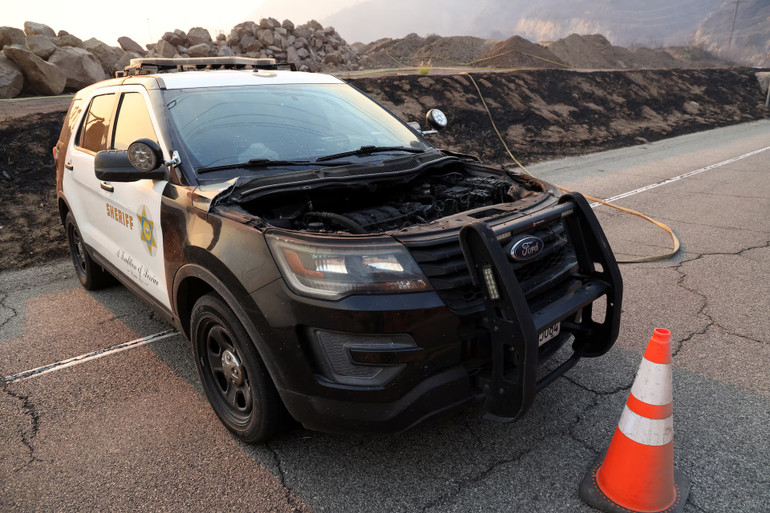 Một chiếc ôtô bị cháy một phần nằm trên đường.