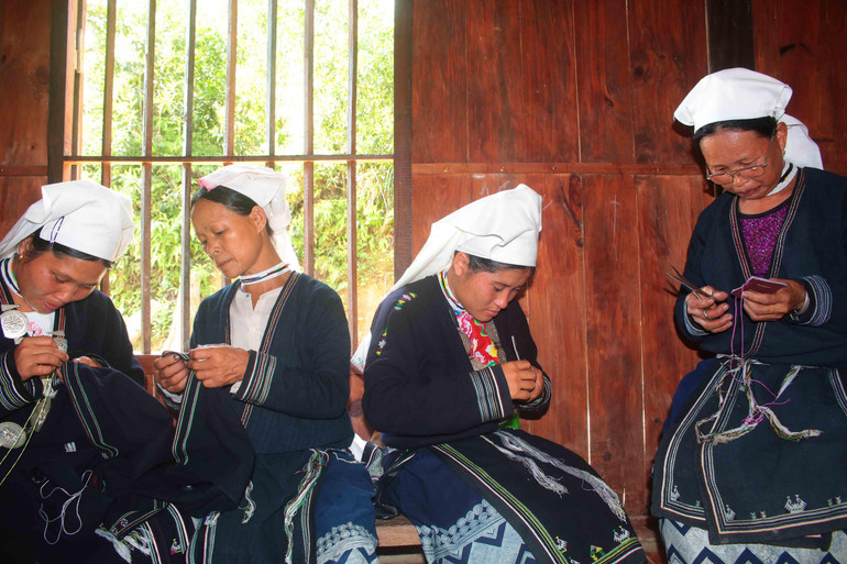 Các thành viên Xưởng thêu thổ cẩm người Dao tập trung sản xuất các sản phẩm.