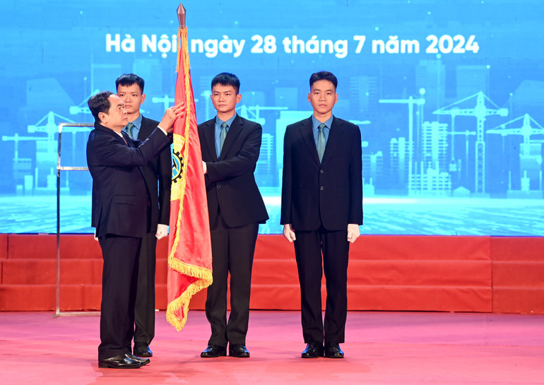 Chủ tịch Quốc hội Trần Thanh Mẫn gắn Huân chương Lao động hạng Nhất lên cờ truyền thống của Tổng Liên đoàn Lao động Việt Nam.