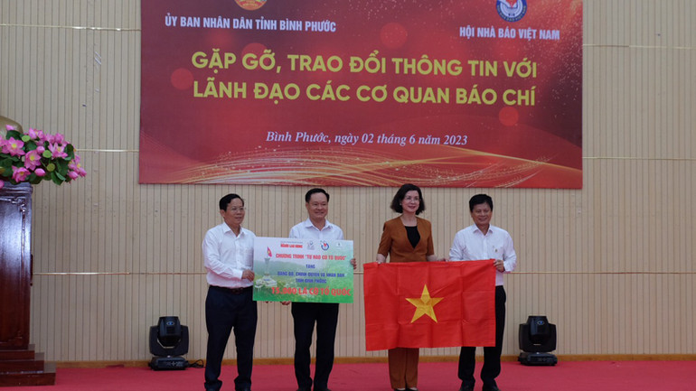 Lãnh đạo tỉnh Bình Phước nhận 15.000 lá cờ từ đoàn công tác.