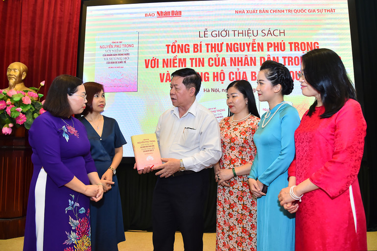 Trưởng Ban Tuyên giáo Trung ương Nguyễn Trọng Nghĩa trao đổi với các đại biểu bên lề buổi ra mắt sách.