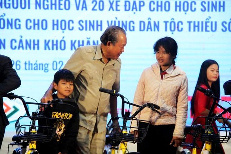 Nguyên Phó Thủ tướng Thường trực Trương Hòa Bình trao xe đạp cho các em học sinh nghèo, khó khăn.