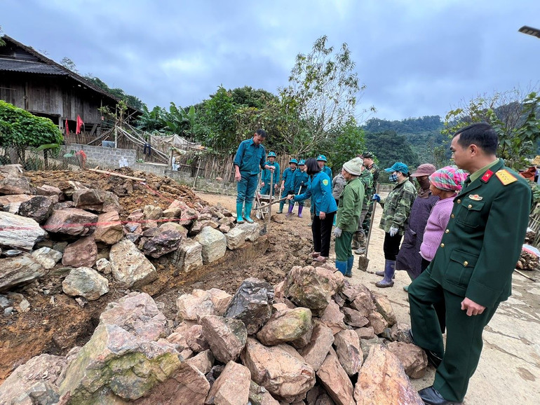 Lãnh đạo huyện Bạch Thông hướng dẫn người dân cách thức xếp đá xây dựng hàng rào.