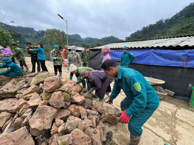 Người dân thôn Thôm Khoan chung tay bê từng viên đá xếp hàng rào.
