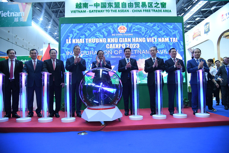 Thủ tướng Phạm Minh Chính và các đại biểu thực hiện nghi thức khai trương Khu gian hàng Việt Nam.