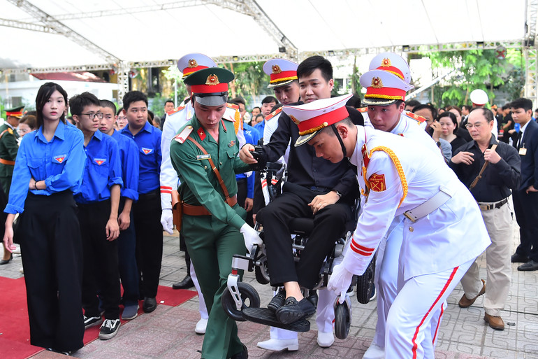 Những người gặp vấn đề về sức khoẻ được lực lượng chức năng hỗ trợ tận tình để vào viếng Tổng Bí thư Nguyễn Phú Trọng.