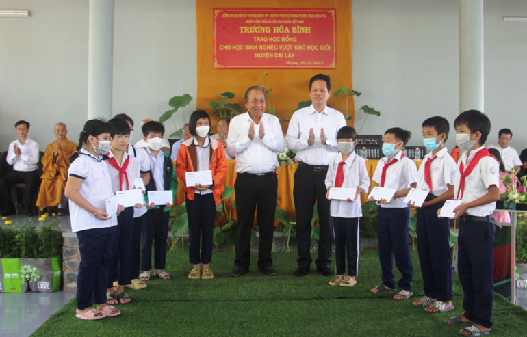 Đồng chí Trương Hòa Bình cùng lãnh đạo tỉnh Tiền Giang tặng quà cho các em học sinh nghèo vượt khó học giỏi.