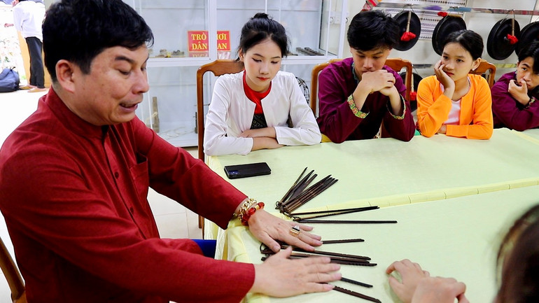 Nghệ nhân Nhân dân Bùi Văn Minh ở huyện Lạc Sơn tỉnh Hòa Bình hướng dẫn các em học sinh tìm hiểu về lịch “Đoi” của người Mường