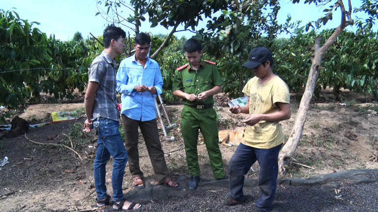 Trưởng thôn A Nẻo (thứ hai từ trái sang) phối hợp công an xã tuyên truyền thu hồi vũ khí, vật liệu nổ.