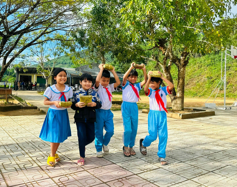 Các em học sinh Trường Phổ thông dân tộc bán trú Tiểu học và Trung học cơ sở Sơn Liên trong niềm vui được nhận bánh chưng từ các cán bộ, chiến sĩ và thầy cô giáo.