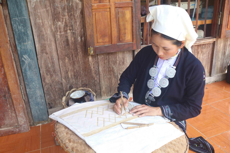 Chấm họa tiết bằng sáp ong trên thổ cẩm.