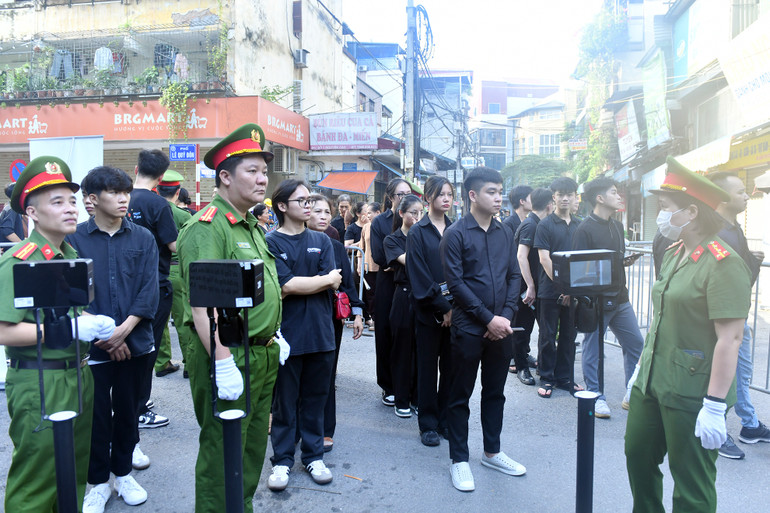 Lực lượng công an hướng dẫn người dân xếp hàng, làm thủ tục để vào viếng Tổng Bí thư Nguyễn Phú Trọng.