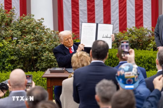 Tổng thống Mỹ Donald Trump ký sắc lệnh áp mức thuế đối ứng mới tại Nhà Trắng, ngày 2/4/2025. (Ảnh: THX/TTXVN)