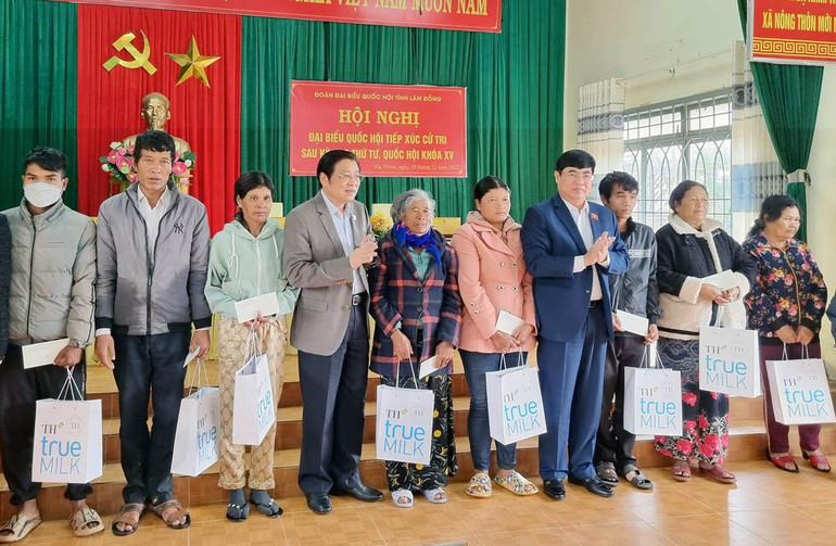 Đồng chí Phan Đình Trạc và Trần Đình Văn trao quà tặng các gia đình chính sách xã Đạ Nhim.