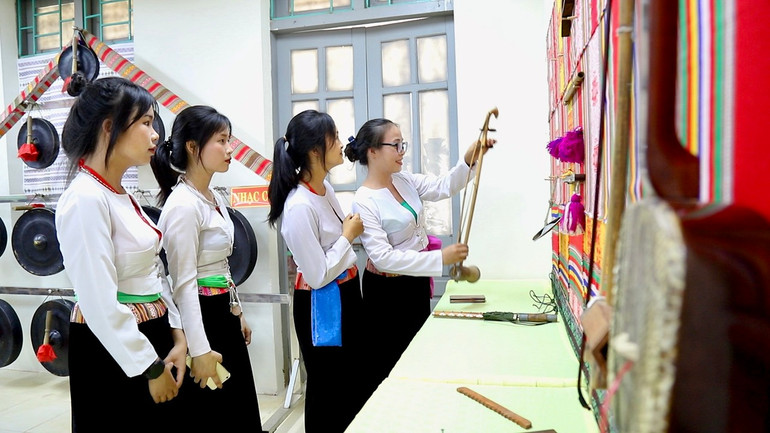 Cô giáo Trịnh Thị Hào (đứng trong cùng) -Trường THPT Quyết thắng hướng dẫn các em trongCLB tìm hiểu về nhạc cụ dân tộc Mường.