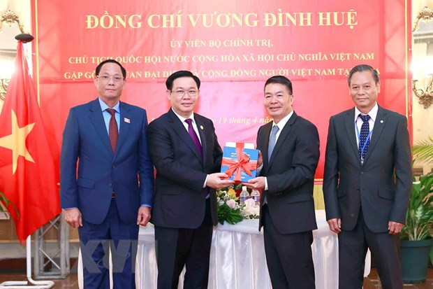 Chủ tịch Quốc hội Vương Đình Huệ trao tập sách tượng trưng (tủ sách về Bác Hồ) cho Đại sứ và đại diện cộng đồng. (Ảnh: TTXVN)