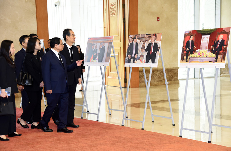 Thủ tướng Phạm Minh Chính giới thiệu với Thủ tướng Hàn Quốc Han Duck Soo một số hình ảnh về hoạt động đối ngoại của cố Tổng Bí thư Nguyễn Phú Trọng.