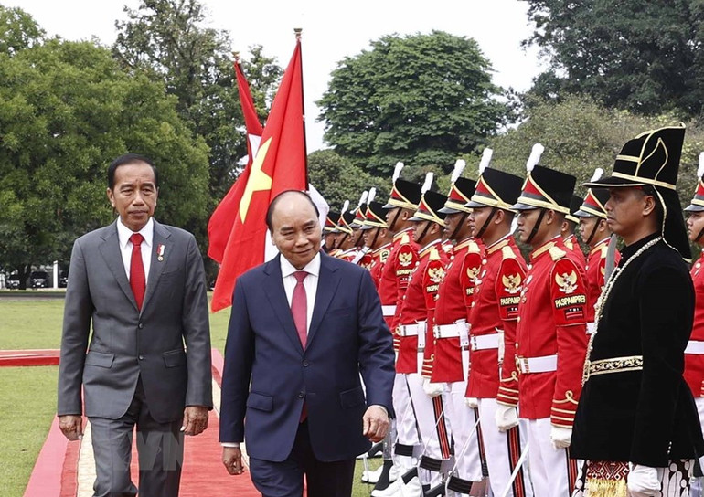 Chủ tịch nước Nguyễn Xuân Phúc và Tổng thống nước Cộng hòa Indonesia Joko Widodo tại lễ đón. (Ảnh: TTXVN)