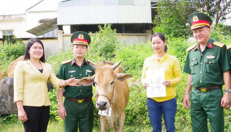 Đại diện Binh đoàn 16 và Ủy ban nhân dân huyện Bù Đăng tặng bò giống cho người nghèo.