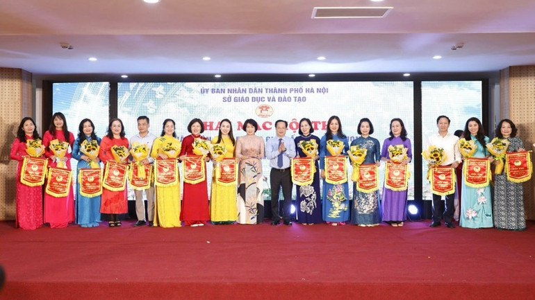 Phó Vụ trưởng Giáo dục Mầm non (Bộ Giáo dục và Đào tạo) Hoàng Thị Dinh và Giám đốc Sở Giáo dục và Đào tạo Hà Nội Trần Thế Cương tặng cờ lưu niệm cho các đơn vị tham dự hội thi.