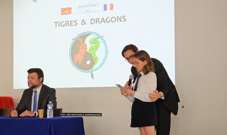 Em Gabrielle Hilly, học sinh lớp 6/12, giới thiệu về logo “Hổ và rồng” được vẽ bởi chính các bạn học sinh lớp 6 hệ Quốc tế. (Ảnh: KHẢI HOÀN) Em Gabrielle Hilly, học sinh lớp 6/12, giới thiệu về logo “Hổ và rồng” được vẽ bởi chính các bạn học sinh lớp 6 hệ Quốc tế. (Ảnh: KHẢI HOÀN)