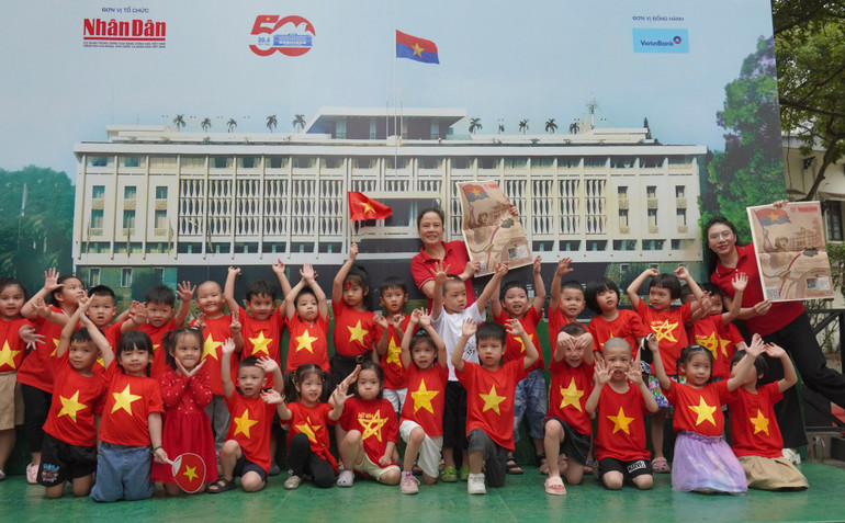 Các bạn nhỏ lớp nhỡ A Trường mầm non Tháng Tám mặc áo cờ đỏ sao vàng háo hức chụp ảnh trong buổi tham quan triển lãm.