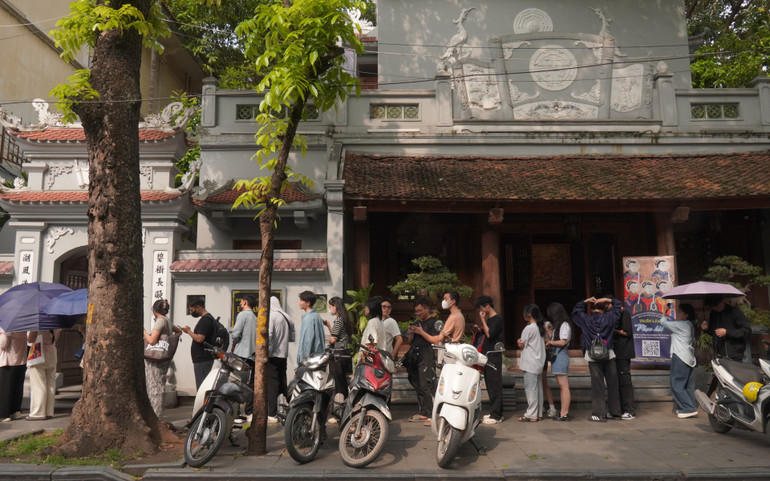 Hàng người xếp hàng qua đình Nam Hương và vẫn tiếp tục dài thêm.