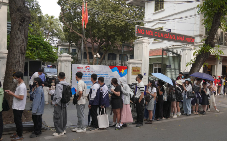 Hàng người kéo dài qua cổng Báo Nhân Dân mặt phố Hàng Trống.