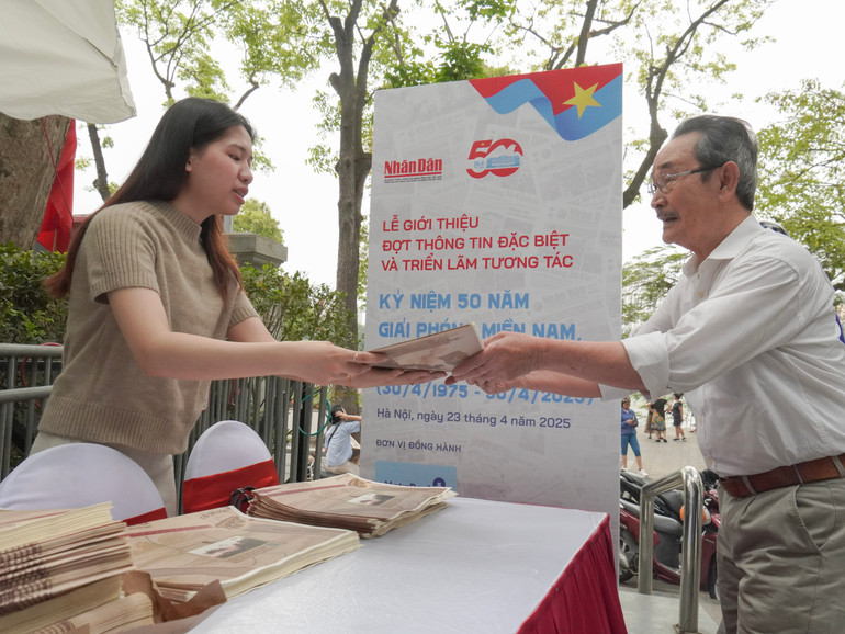 [Ảnh] Du khách xếp hàng nhận ấn phẩm thông tin đặc biệt của Báo Nhân Dân ảnh 2