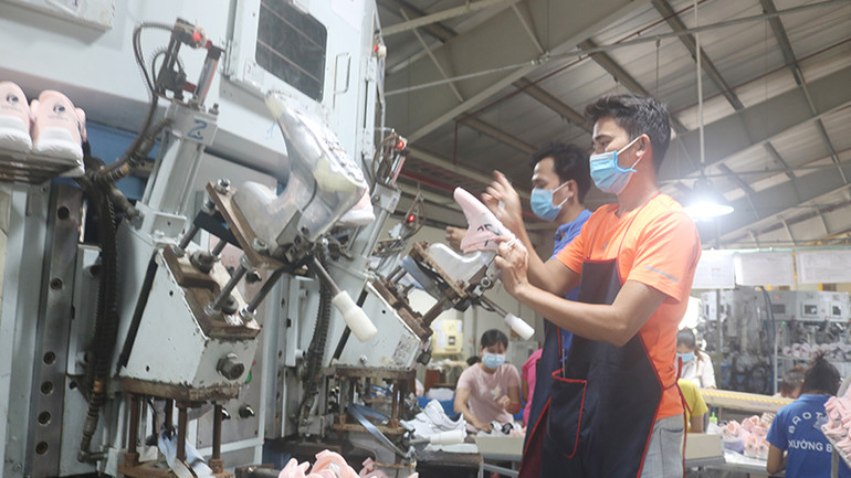 Công nhân, lao động Công ty Trách nhiệm hữu hạn thương mại và sản xuất Bảo Tiên ở xã Song Lộc, huyện Châu Thành đang gia công các sản phẩm giày da xuất khẩu.