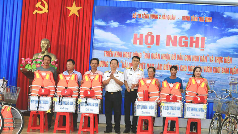 Ngư dân huyện Duyên Hải được các cán bộ, chiến sĩ Vùng 2 Hải quân trao tặng áo phao