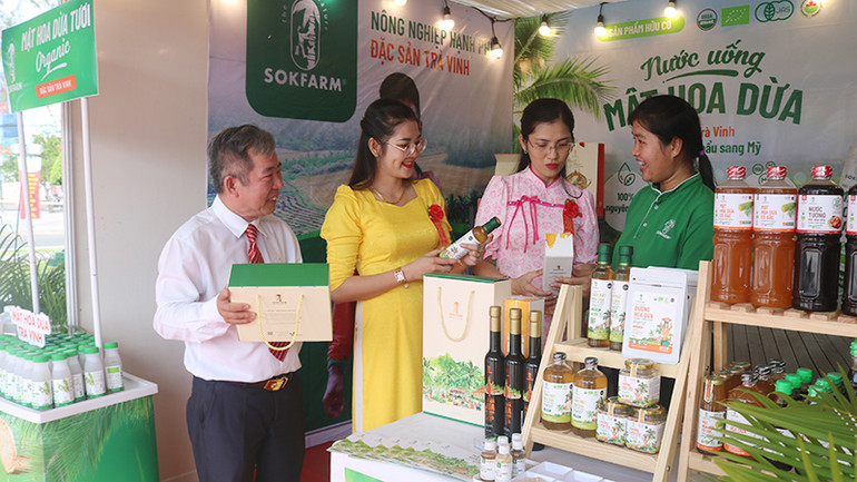 Đại biểu tìm hiểu sản phẩm "Mật hoa dừa Organic Sokfarm" đạt hạng OCOP 5 sao của huyện Tiểu Cần.