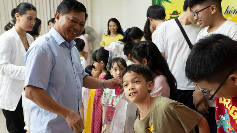 Đại sứ Nguyễn Huy Tăng tặng quà cho các cháu thiếu nhi. (Ảnh: Nguyễn Hiệp)