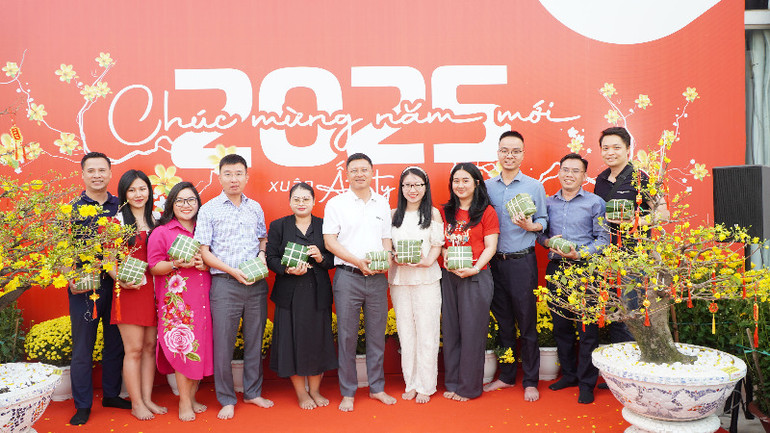 Tổng Giám đốc Metfone Cao Mạnh Đức (giữa) và đại diện các đội tham gia thi gói bánh chưng chia sẻ sản phẩm của nhóm mình. (Ảnh: HUY VŨ)