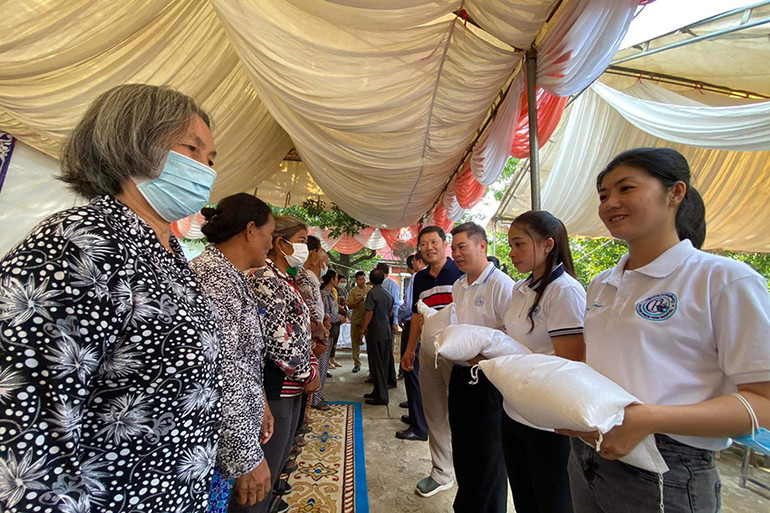 Cán bộ Đại sứ quán Việt Nam và Bệnh viện Chợ rẫy Phnom Penh trao quà cho bà con. (Ảnh: Sơn Xinh)