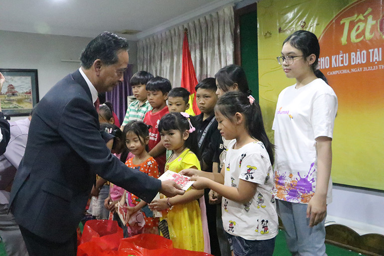Chủ tịch Hội Khmer-Việt Nam tại Campuchia Châu Văn Chi trao quà Tết cho học sinh con em người gốc Việt Nam. Ảnh: NGUYỄN HIỆP