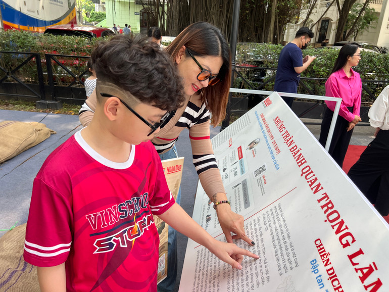 Chị Hoàng Thúy Khanh cùng con tìm hiểu, khám phá nhiều thông tin về trận đánh quan trọng làm nên chiến thắng lịch sử Giải phóng miền nam, thống nhất đất nước. (Ảnh: MINH PHƯƠNG)