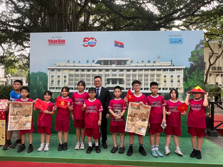 Nhóm học sinh Trường tiểu học Vinschool rất thích thú khi được chụp ảnh cùng Tổng Biên tập Báo Nhân Dân Lê Quốc Minh. (Ảnh: MINH PHƯƠNG)