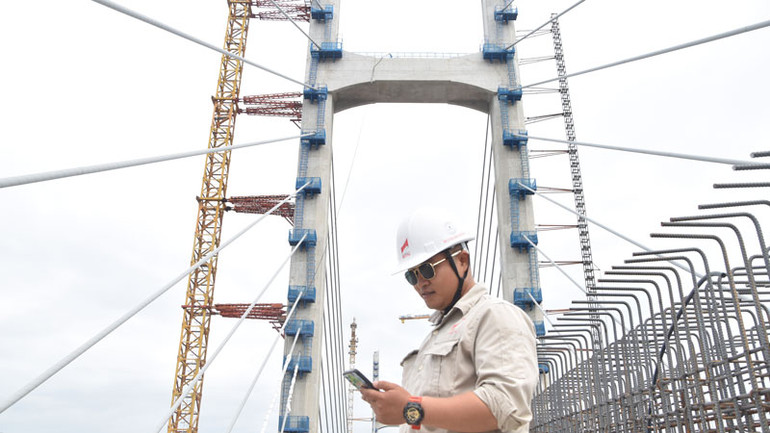 Tranh thủ giờ giải lao, anh Dương Văn Nguyên, cán bộ kỹ thuật phụ trách thi công của Công ty cổ phần Xây dựng và Lắp máy Trung Nam gọi điện về hỏi thăm gia đình trong ngày Tết Dương lịch.