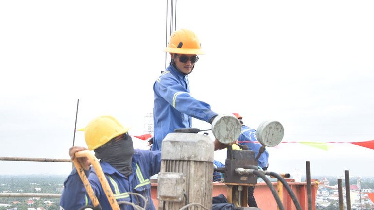 Các công nhân thi công trao đổi công việc với nhau.