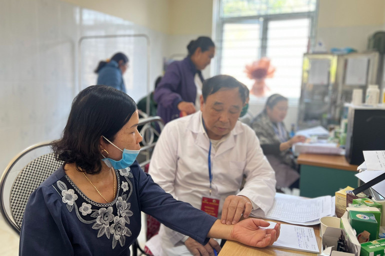 GS, TS, Bác sĩ Trương Việt Bình, Chủ tịch Hội Nam y Việt Nam khám và kê đơn cho người dân.