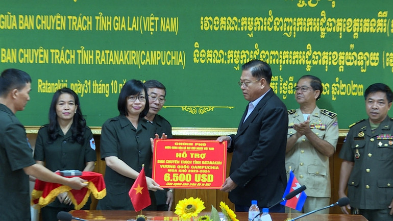 Phó Chủ tịch Ủy ban nhân dân tỉnh Gia Lai Nguyễn Thị Thanh Lịch (trái) trao tiền hỗ trợ của Chính phủ Việt Nam cho Ban Chuyên trách tỉnh Ratanakiri. (Ảnh: ĐỨC HẢI)