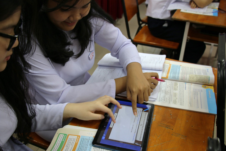 Học sinh trải nghiệm tương tác bài giảng trên thiết bị công nghệ.