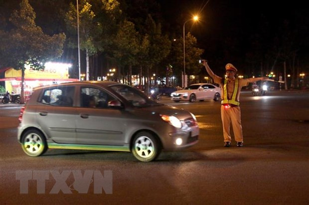 Cảnh sát giao thông dừng một ô-tô để kiểm tra nồng độ cồn. (Ảnh: Nguyễn Thanh/TTXVN)