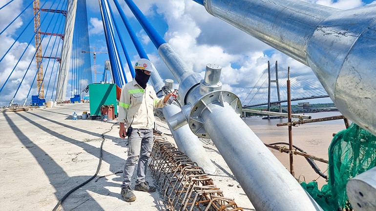 Công nhân đang trang trí những sợi dây văng cầu Mỹ Thuận 2.