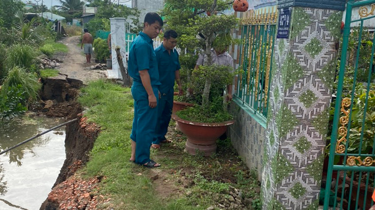 Lực lượng dân quân hỗ trợ người dân di dời tài sản đến nơi an toàn.