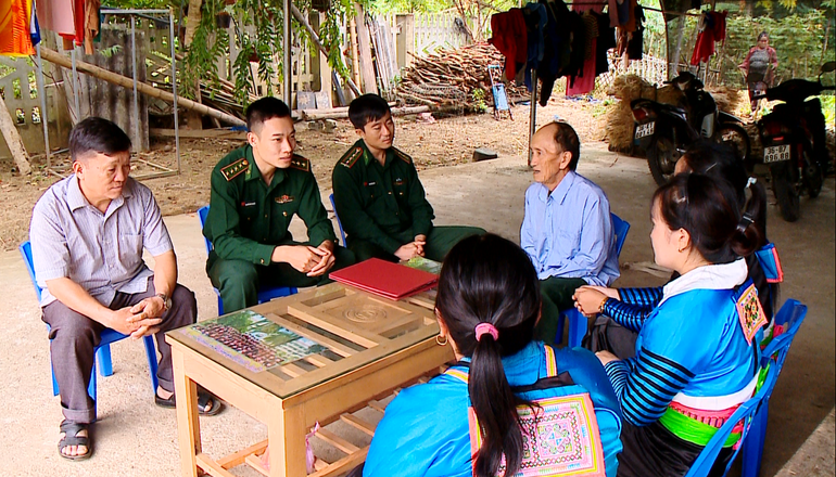 Ông Lâu Minh Pó (ngoài cùng bên trái) cùng Bộ đội Biên phòng vận động người dân xóa bỏ hủ tục, xây dựng nếp sống mới. (Ảnh Trang Nhung)